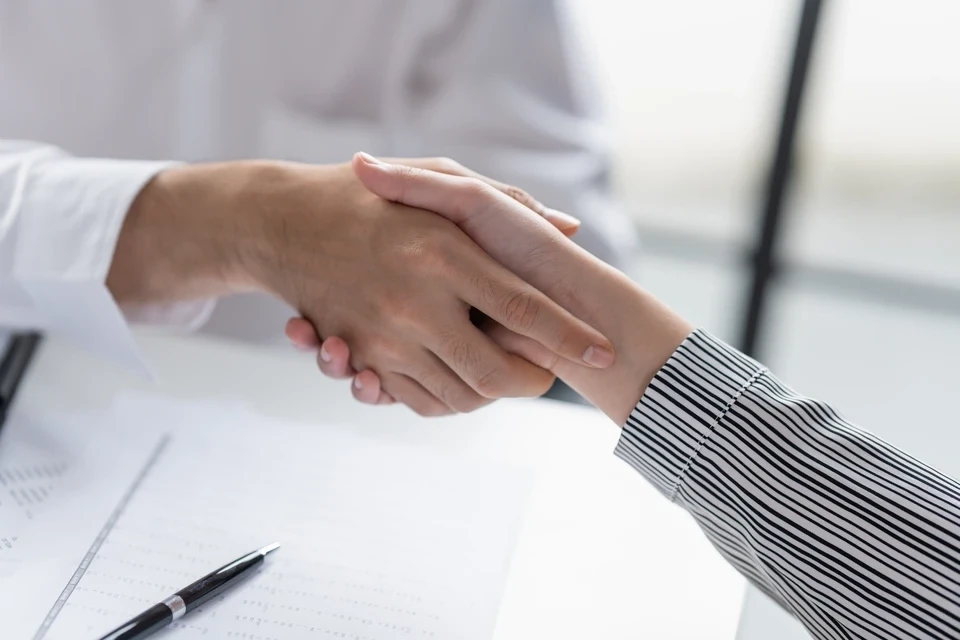 Technicien en tenue professionnelle discutant avec un propriétaire dans un salon lumineux, tenant des brochures ou des devis, montrant des documents explicatifs avec gestes pédagogues. L'atmosphère doit traduire la transparence et le conseil honnête, sans vente agressive.